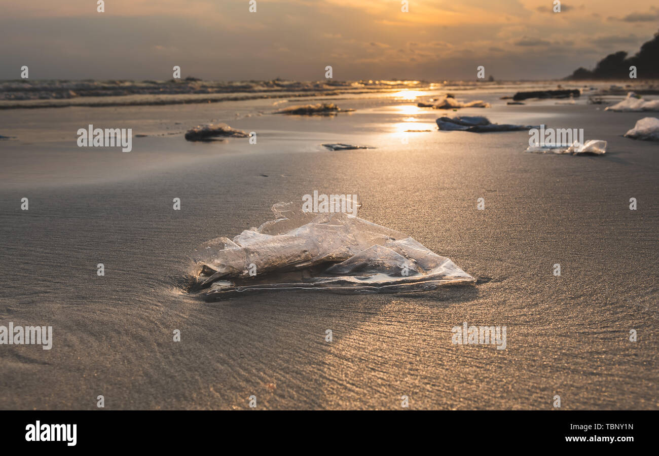 Immondizia di plastica sulla spiaggia in mare inquinamento scape ambiente con illuminazione sun. Foto Stock