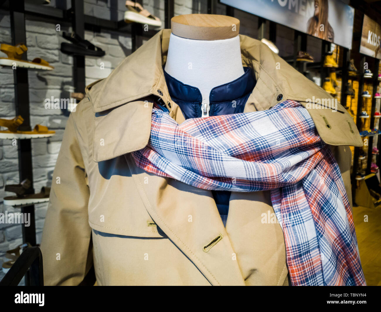Un manichino visualizza le ultime fasionable sciarpa, mac e giacca in un negozio Foto Stock