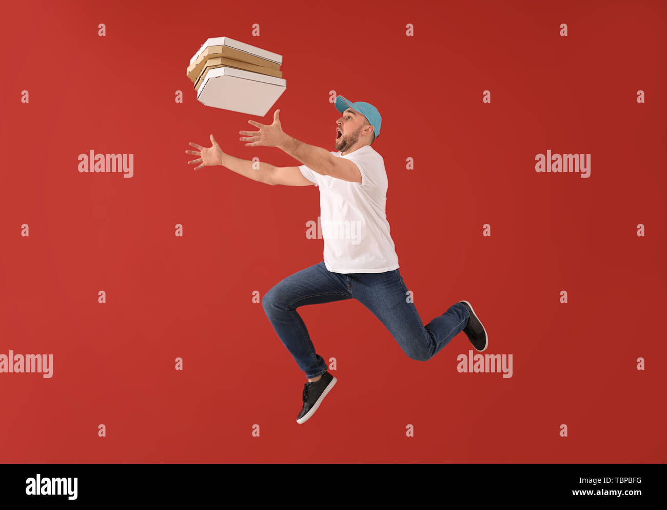 Jumping corriere maschio con scatole per pizza sul colore di sfondo Foto Stock