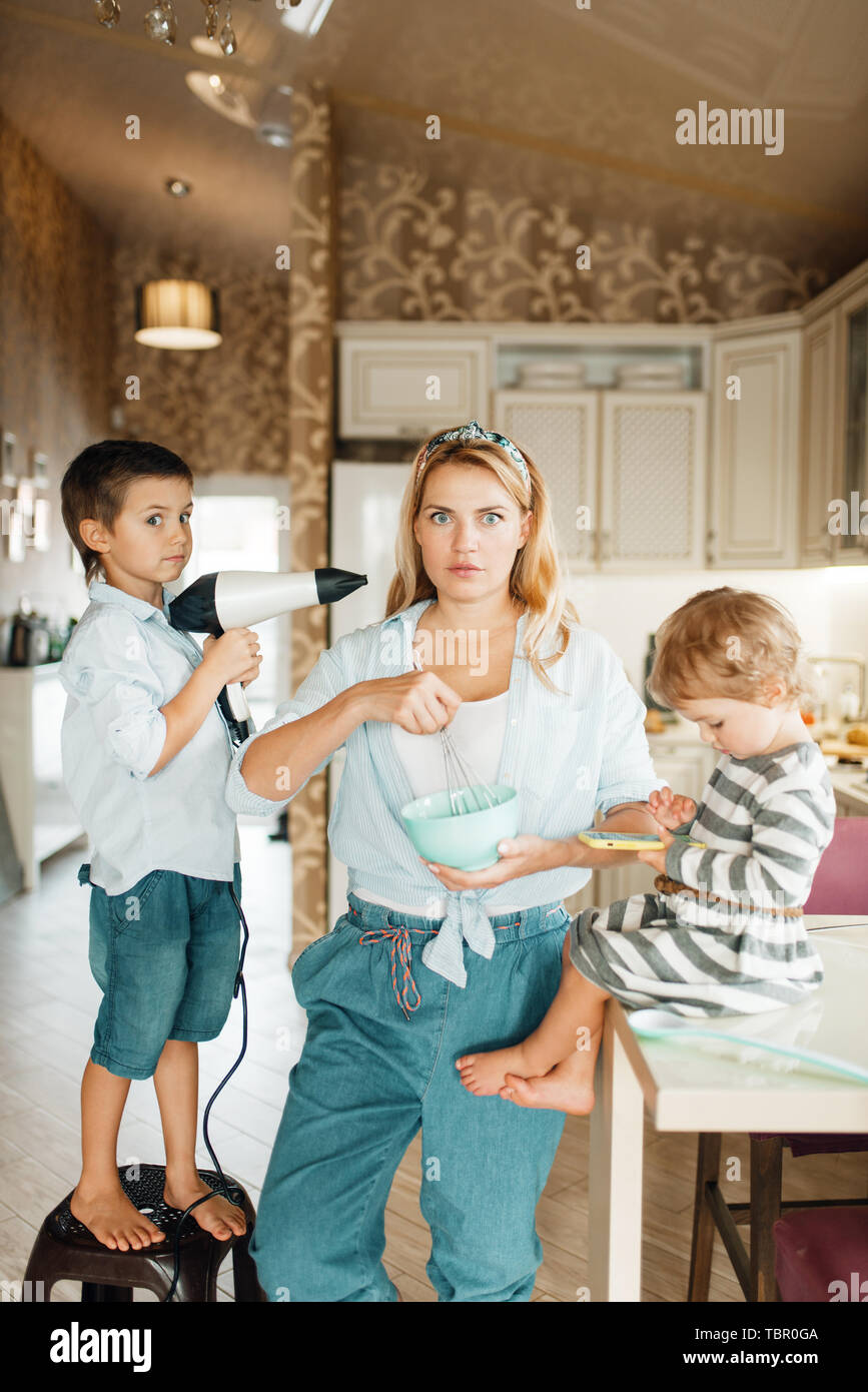 La madre e i suoi bambini cucinare la pasta con il cioccolato Foto Stock