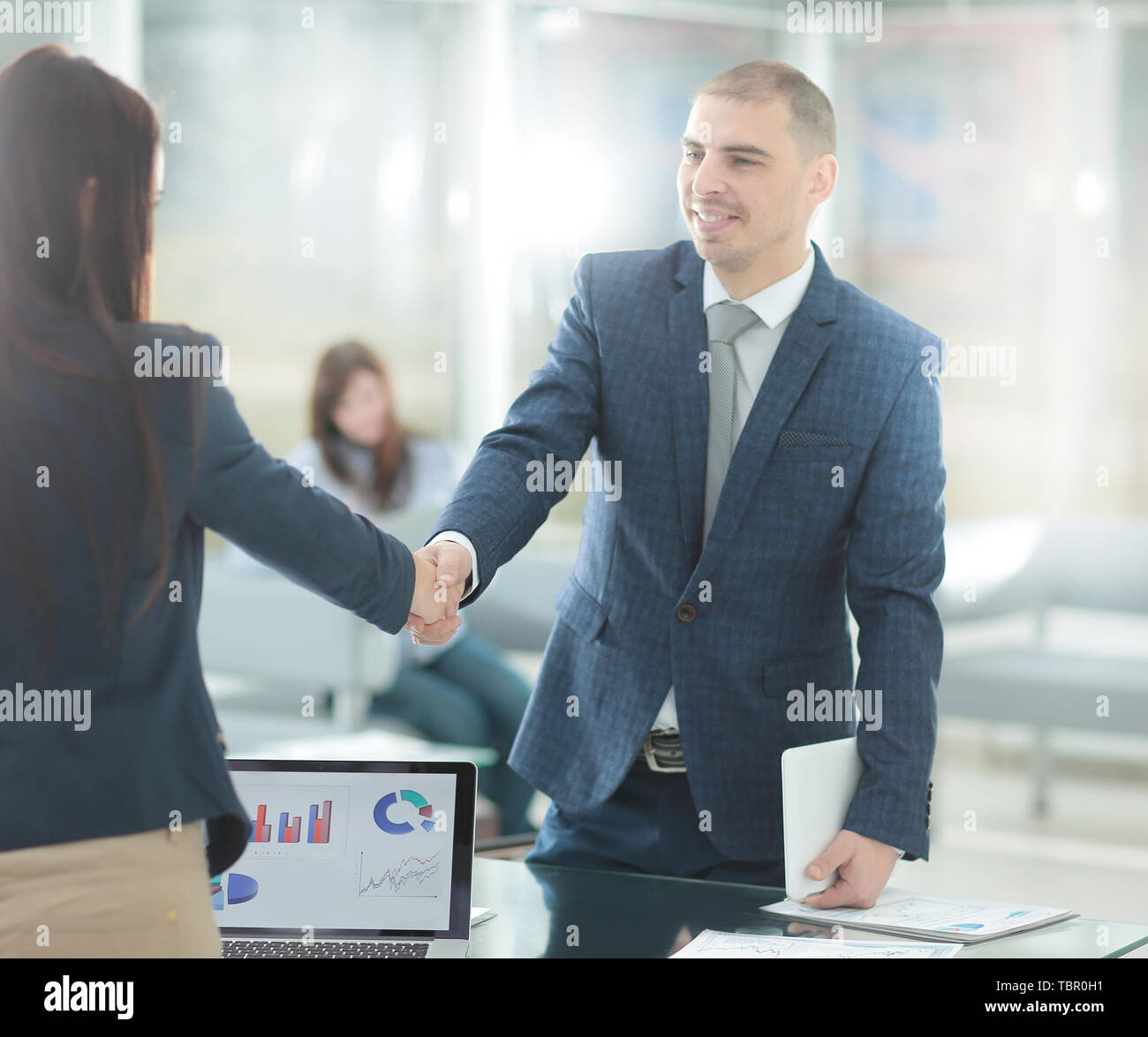 Business donna saluto il client con una stretta di mano. Foto Stock