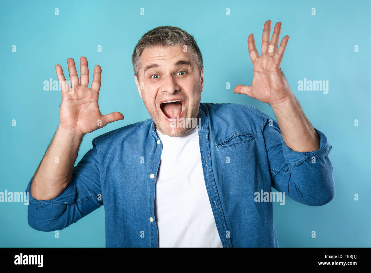 Urlando uomo maturo sul colore di sfondo Foto Stock