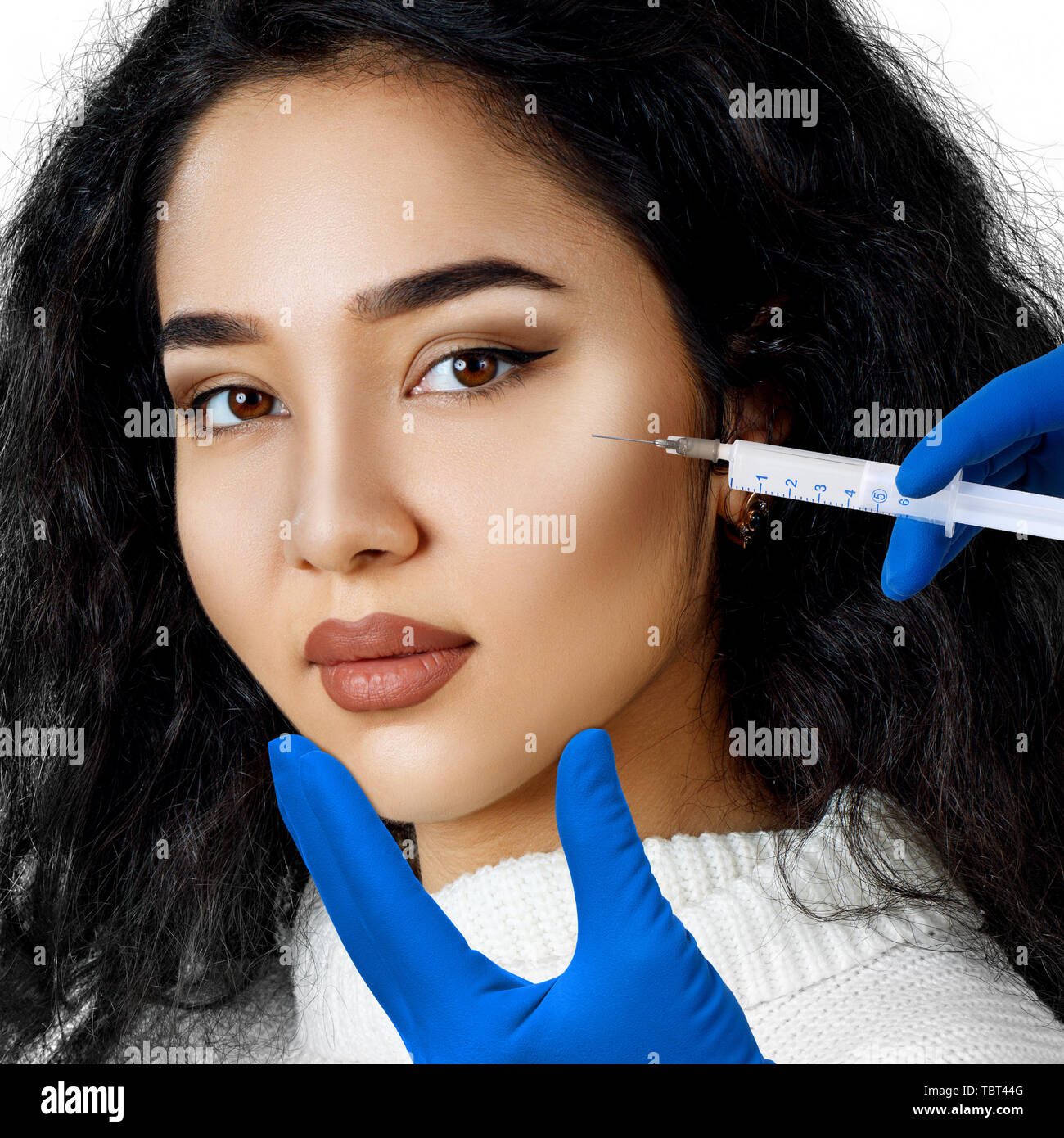 Bruna giovane donna di ottenere prodotti cosmetici di iniezione. Foto Stock