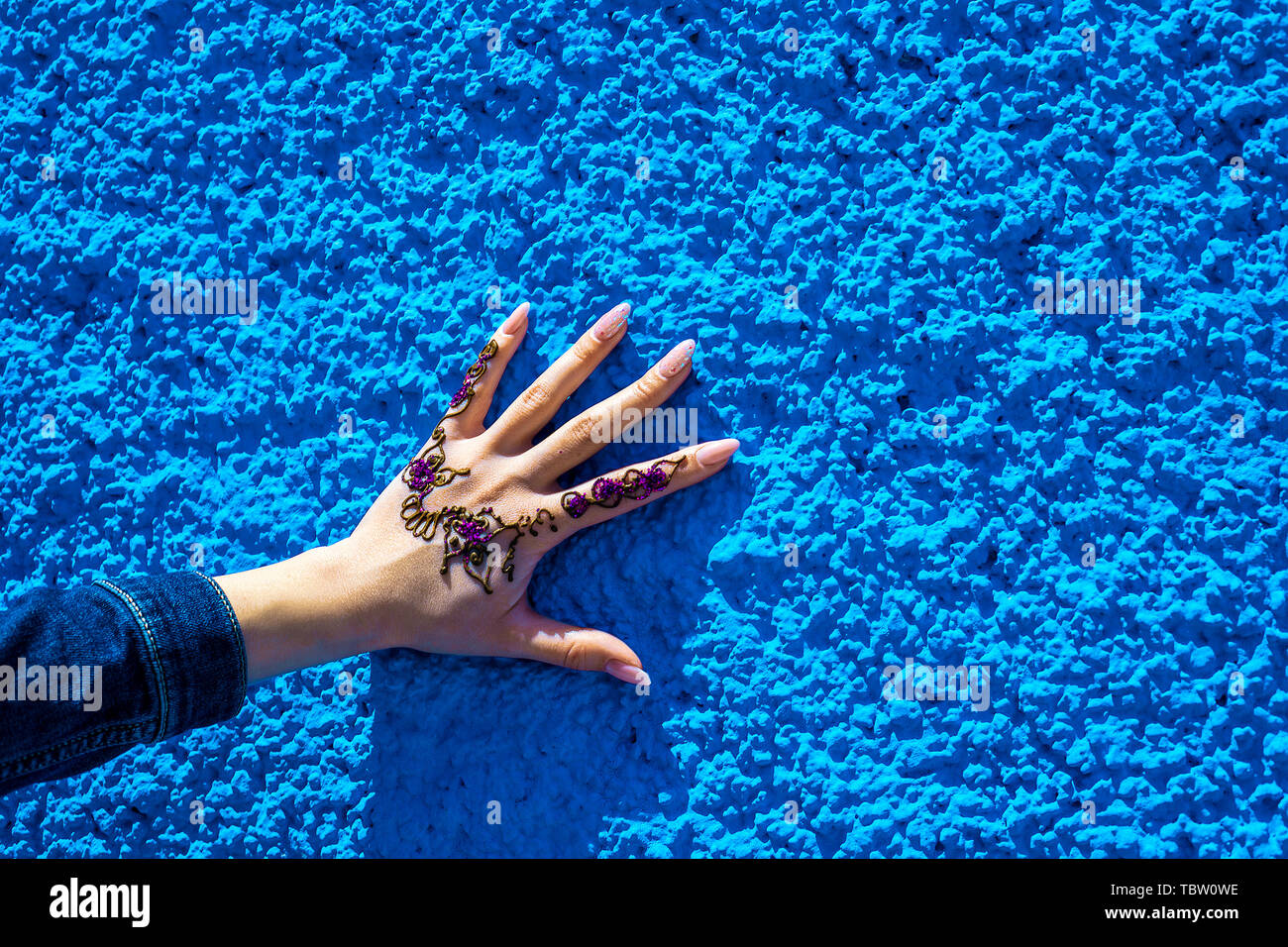 Braccio con un tradizionale henna tattoo sullo sfondo della parete di blu. Rabat, Marocco. Africa Foto Stock