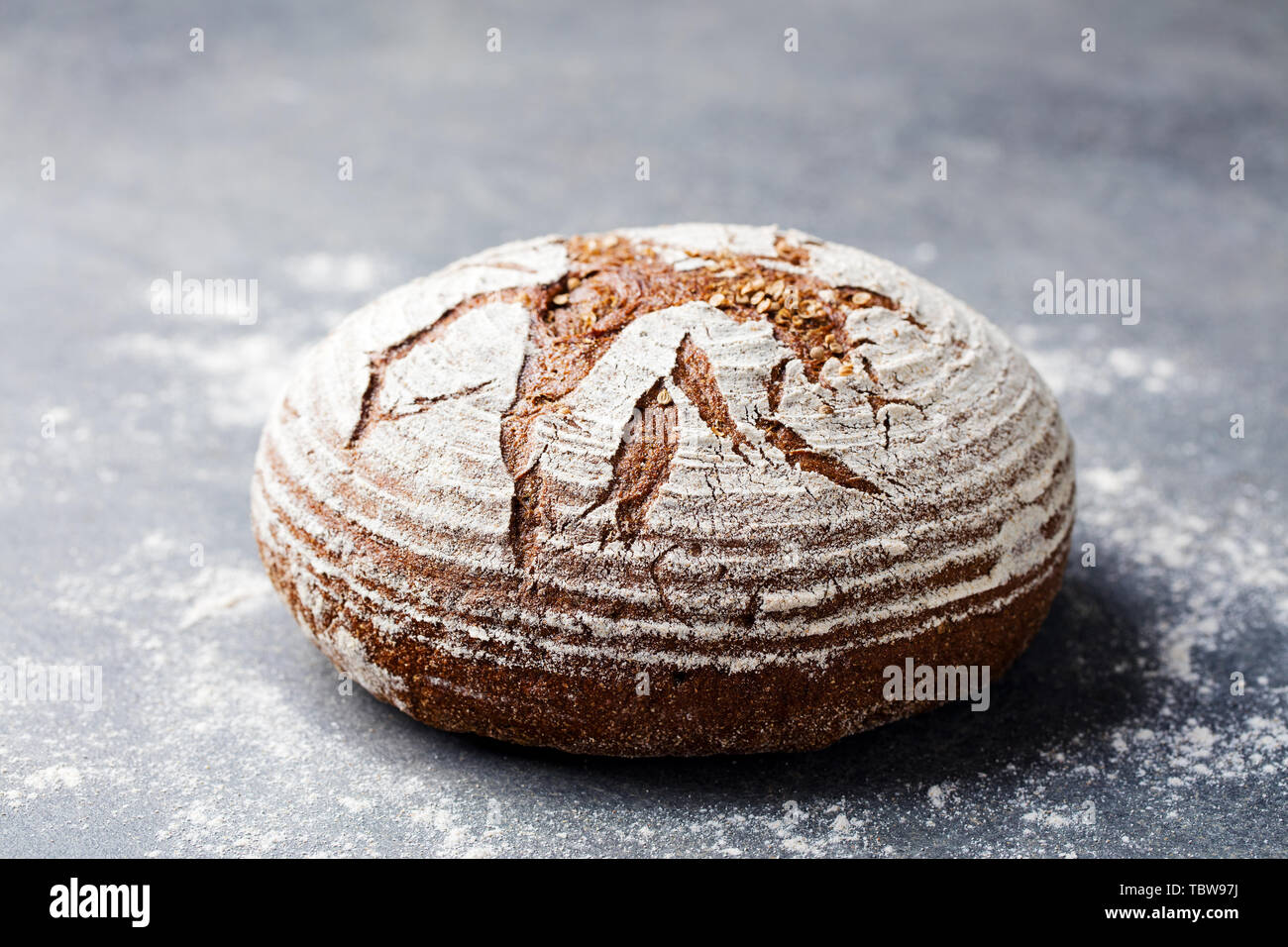 Pane di segale, grano intero su sfondo grigio. Copia dello spazio. Foto Stock