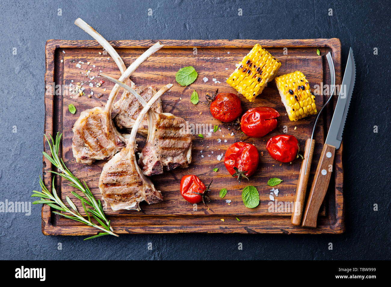 Costolette di agnello grigliate sul tagliere con verdure alla griglia. Vista dall'alto. Foto Stock