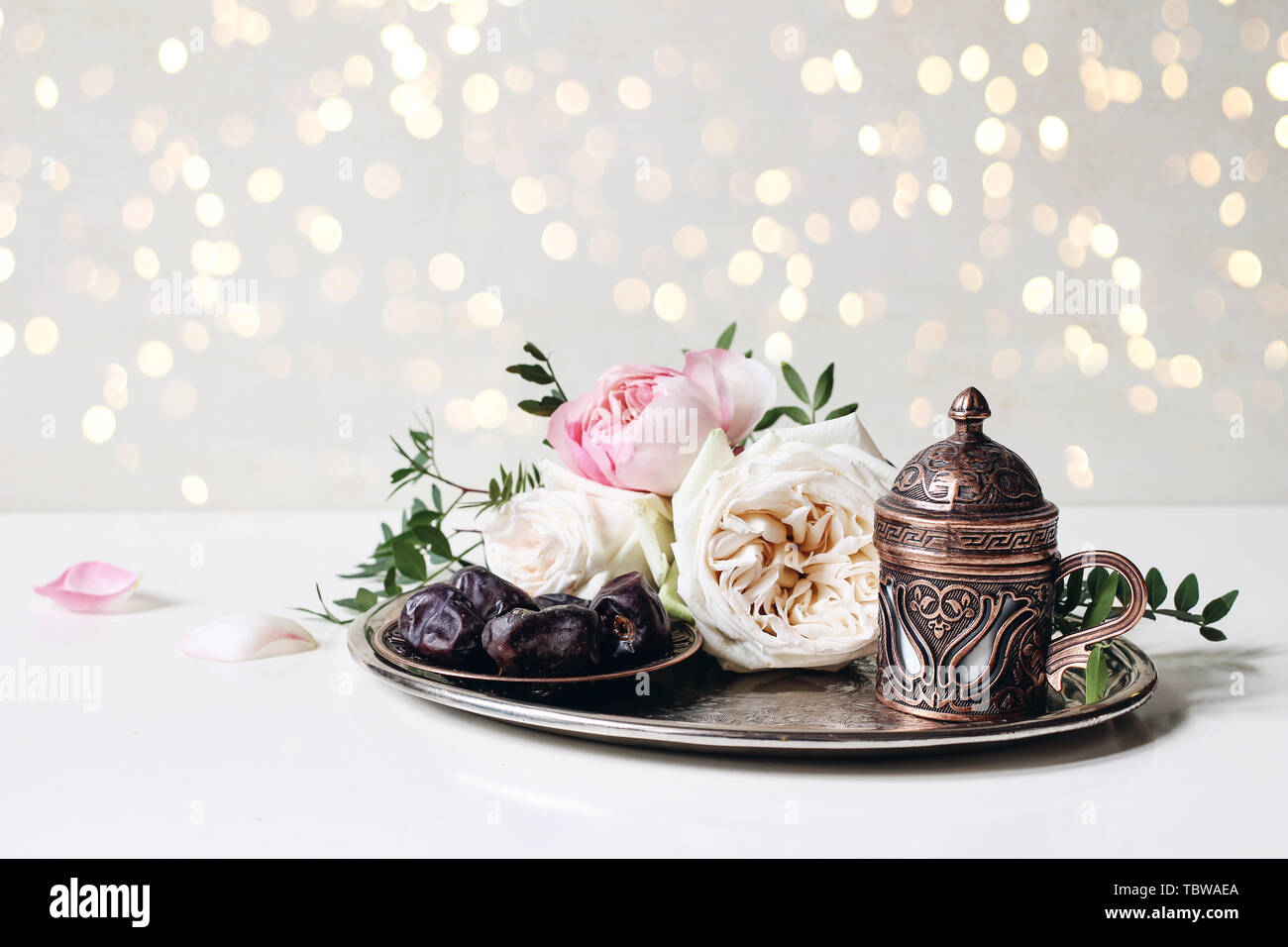 Il Ramadan Kareem bigliettino, invito. Iftar cena. Musulmani Eid ul Adha banner. Piastra con date di frutta, bronzo tazza di caffè, le rose rosa e verde bra Foto Stock