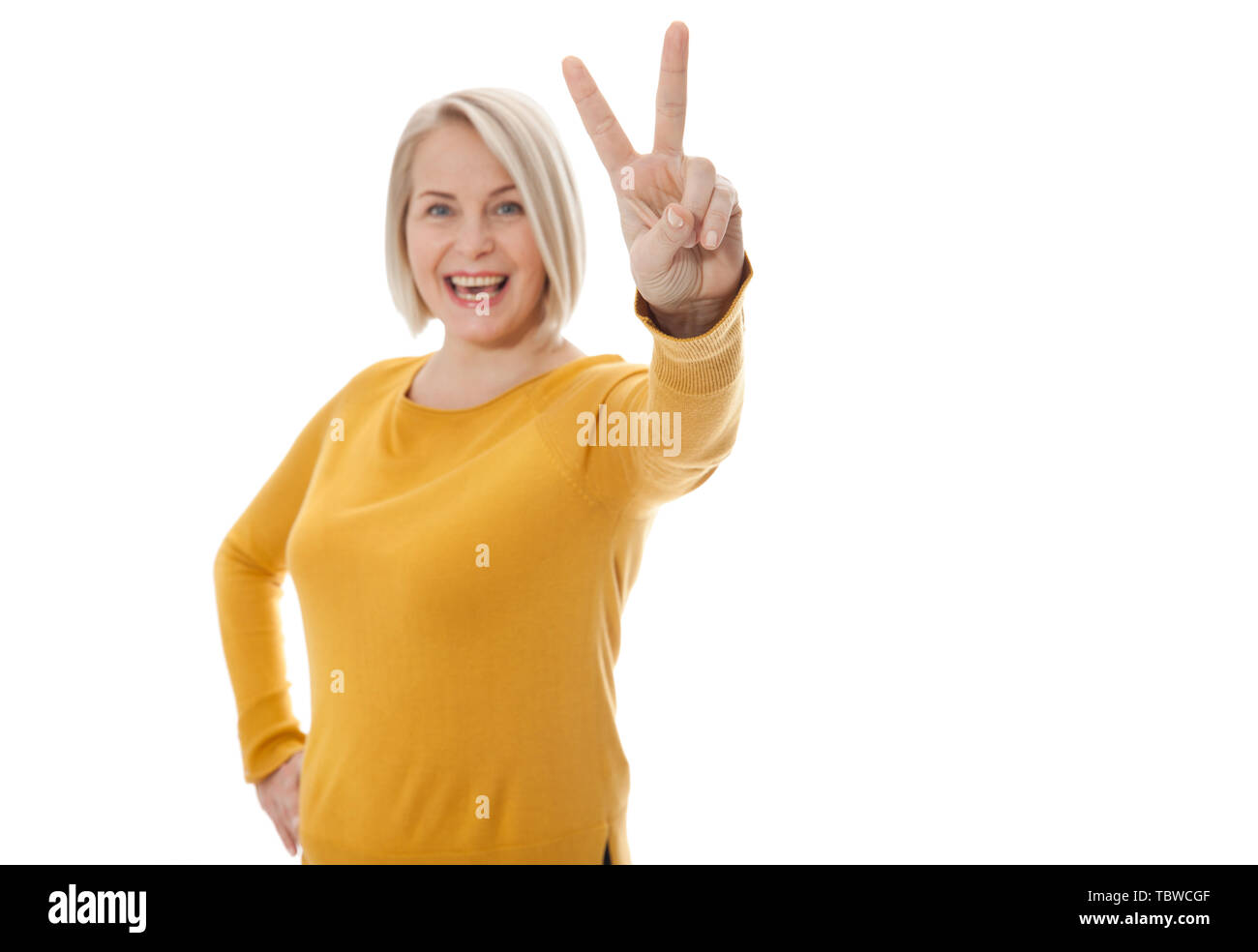 Felice Excited donna di mezza età che mostra il segno della vittoria Foto Stock