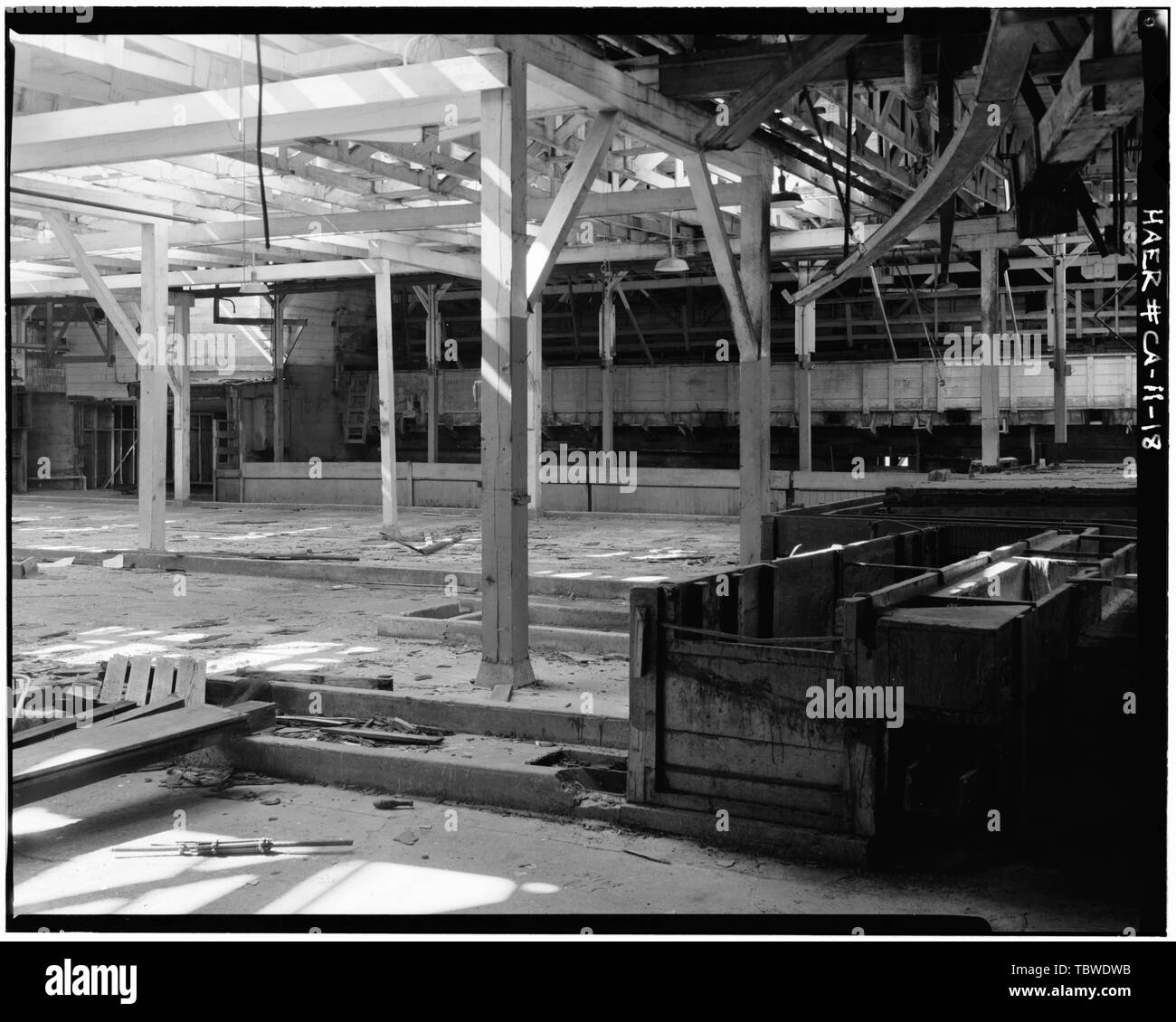 PIANO PRINCIPALE VASCHE DI CONTENIMENTO piano principale, guardando le vasche di contenimento contro la parete ovest, da cui si vedono le saracinesche sporgenti. Serbatoi di tenuta in legno rinunciati a destra. Si notano stretti fumi di legno attraverso i quali i pesci sono stati chiusi in vasche di contenimento e di brasatura. Hovden Cannery, 886 Cannery Row, Monterey, Monterey County, California Foto Stock