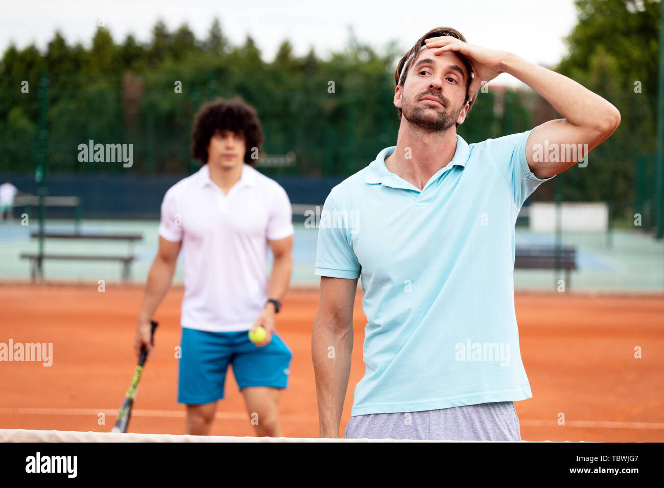 Deluso giocatore di tennis giocando a tennis su corte Foto Stock