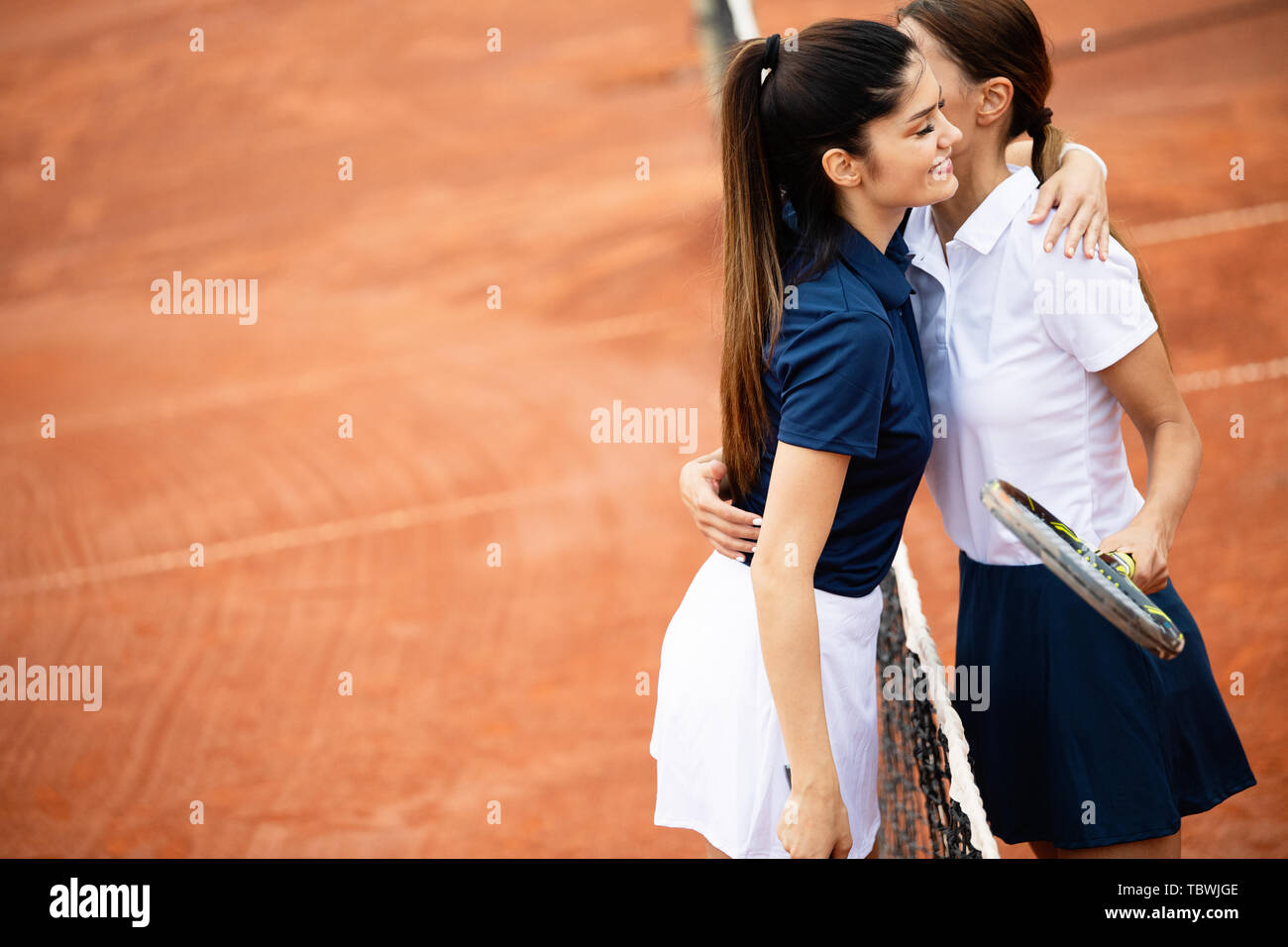 Giovani felici donne amici a giocare a tennis Campo da tennis Foto Stock