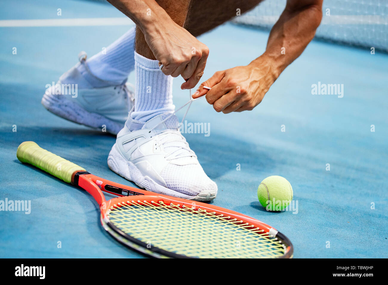 Atleta di Tennis player sta preparando la legatura lacci delle scarpe durante il gioco all'aperto Foto Stock
