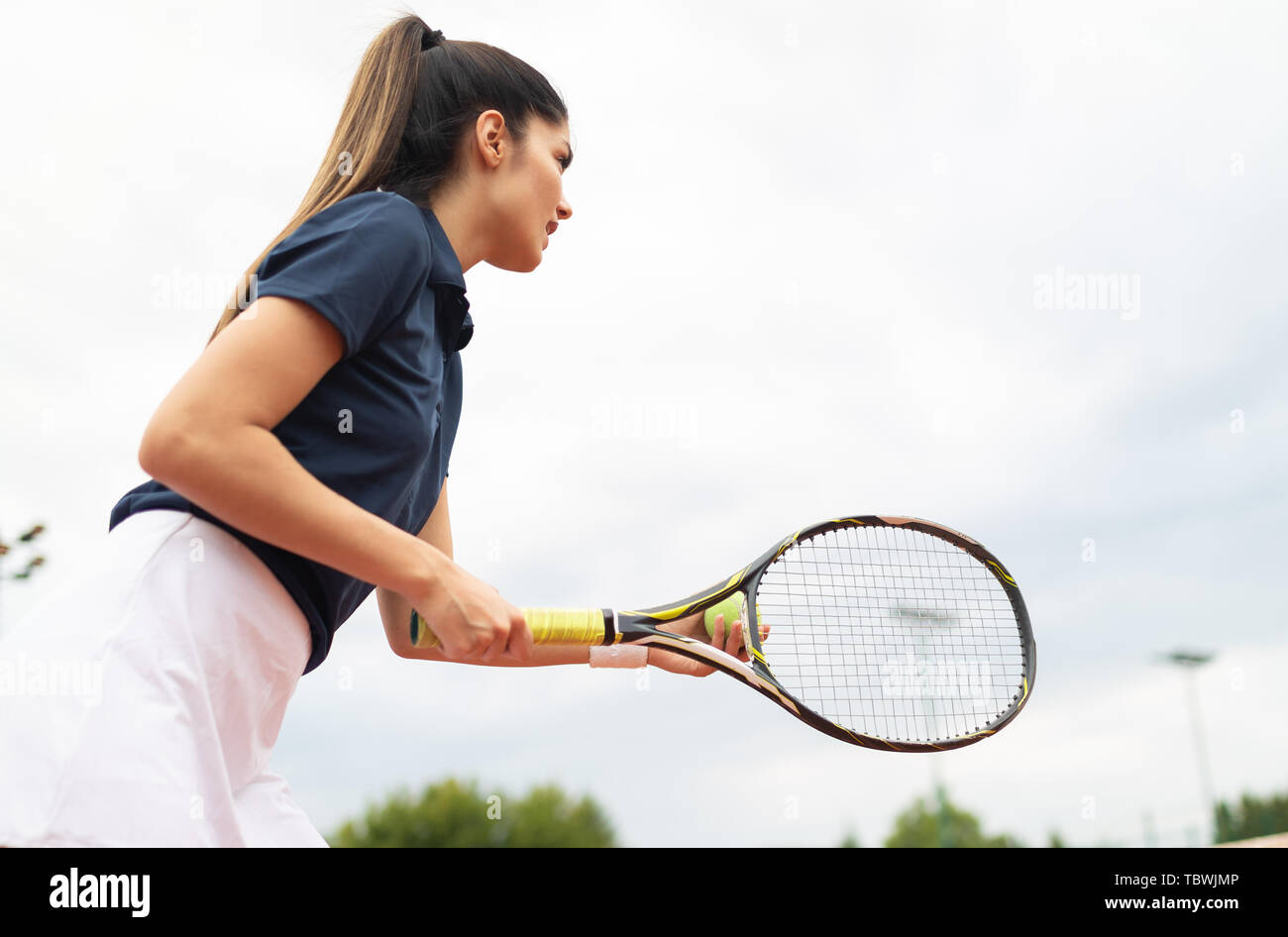 Giovane donna felice a giocare a tennis Campo da tennis Foto Stock