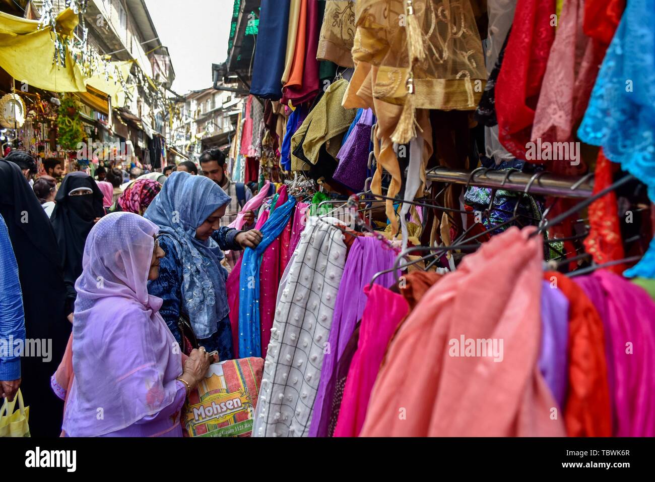 Le donne del Kashmir shopping prima della festa musulmana Eid al-Fitr ad un mercato locale a Srinagar. Mercati di tutto il mondo musulmano testimonianza un enorme centro commerciale rush in preparazione per l'Eid al-Fitr, una festa che segna la fine del musulmano il mese di digiuno del Ramadan. Foto Stock