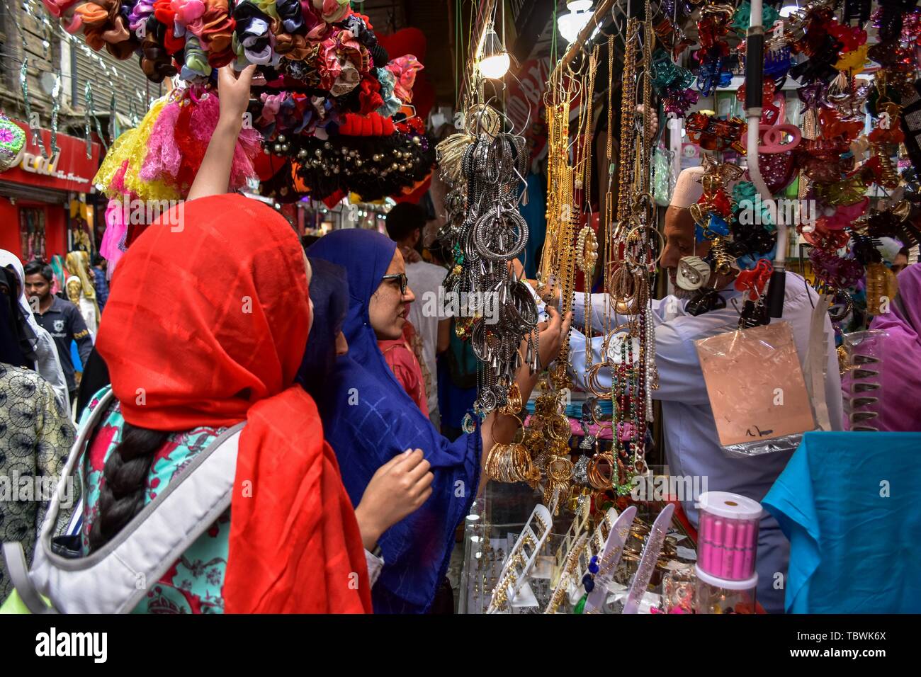 Le donne del Kashmir shopping prima della festa musulmana Eid al-Fitr ad un mercato locale a Srinagar. Mercati di tutto il mondo musulmano testimonianza un enorme centro commerciale rush in preparazione per l'Eid al-Fitr, una festa che segna la fine del musulmano il mese di digiuno del Ramadan. Foto Stock