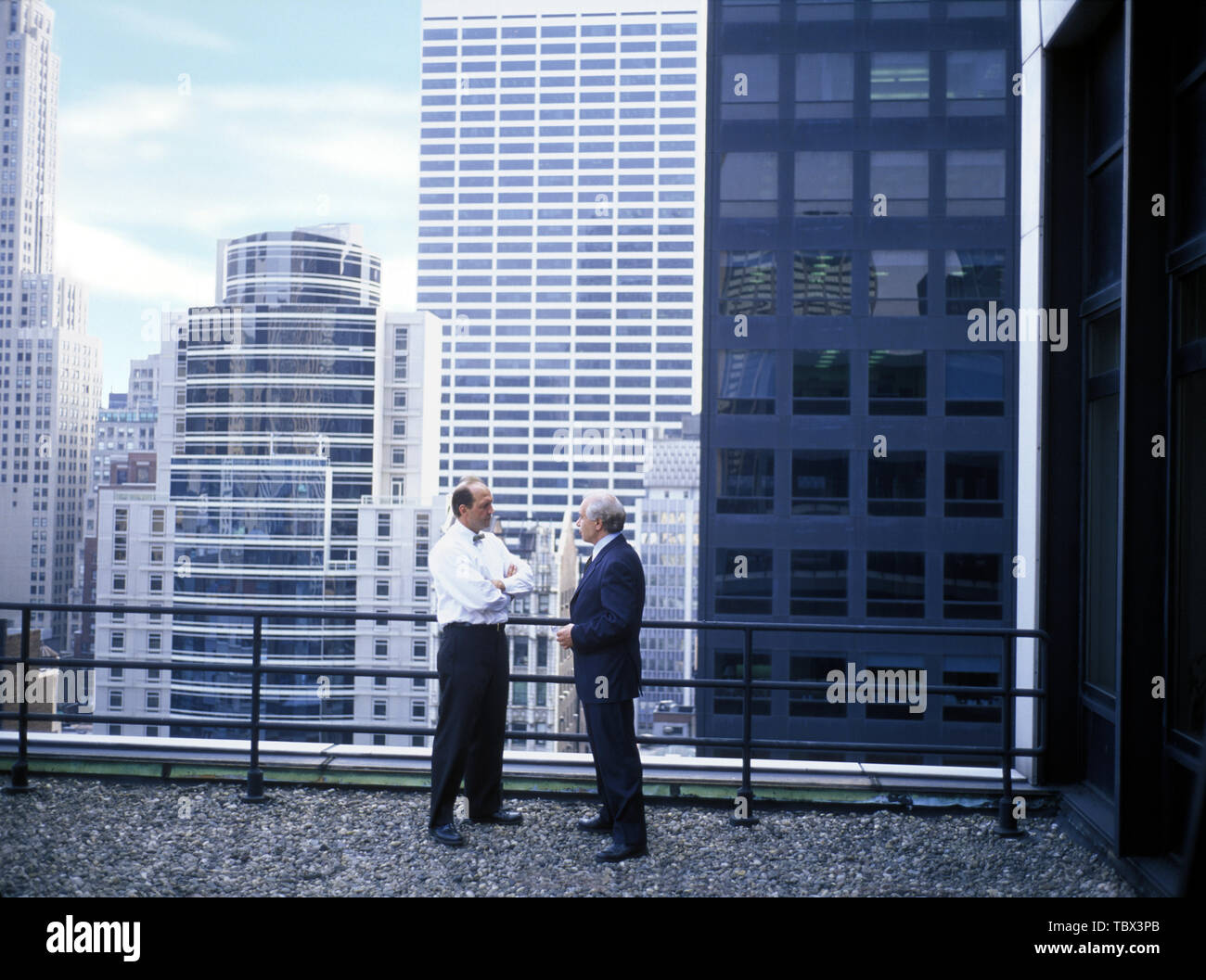Due imprenditore maturo in piedi accanto ad una ringhiera su un balcone in città. Foto Stock