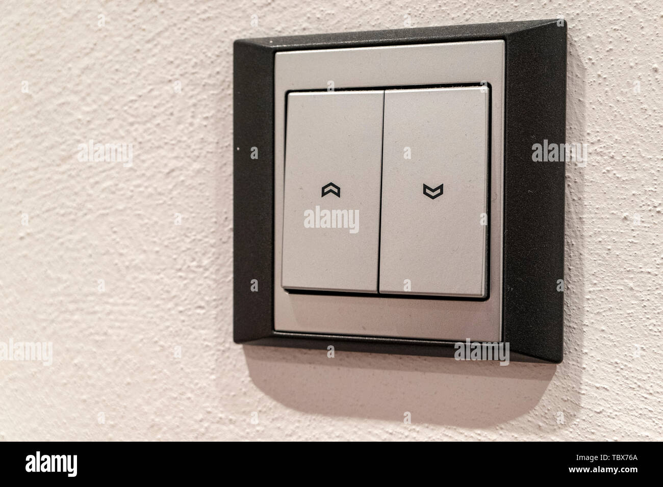 Interruttore per su e giù per la tenda in grigio su un bianco muro di casa Foto Stock