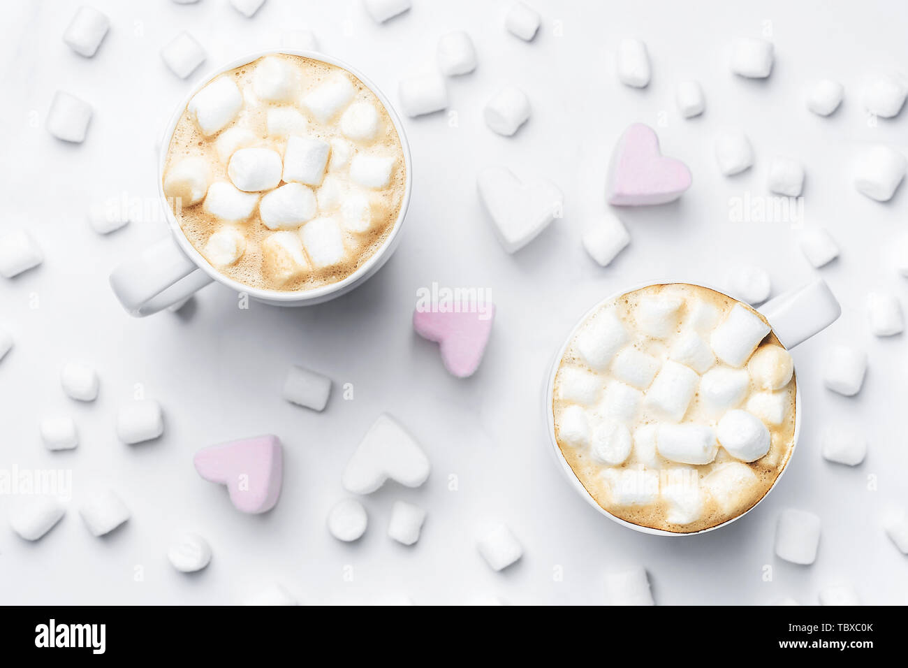 Romantico accogliente da scrivania con due tazze di caffè con marshmallows sulla tavola di marmo. Vista dall'alto. Foto Stock