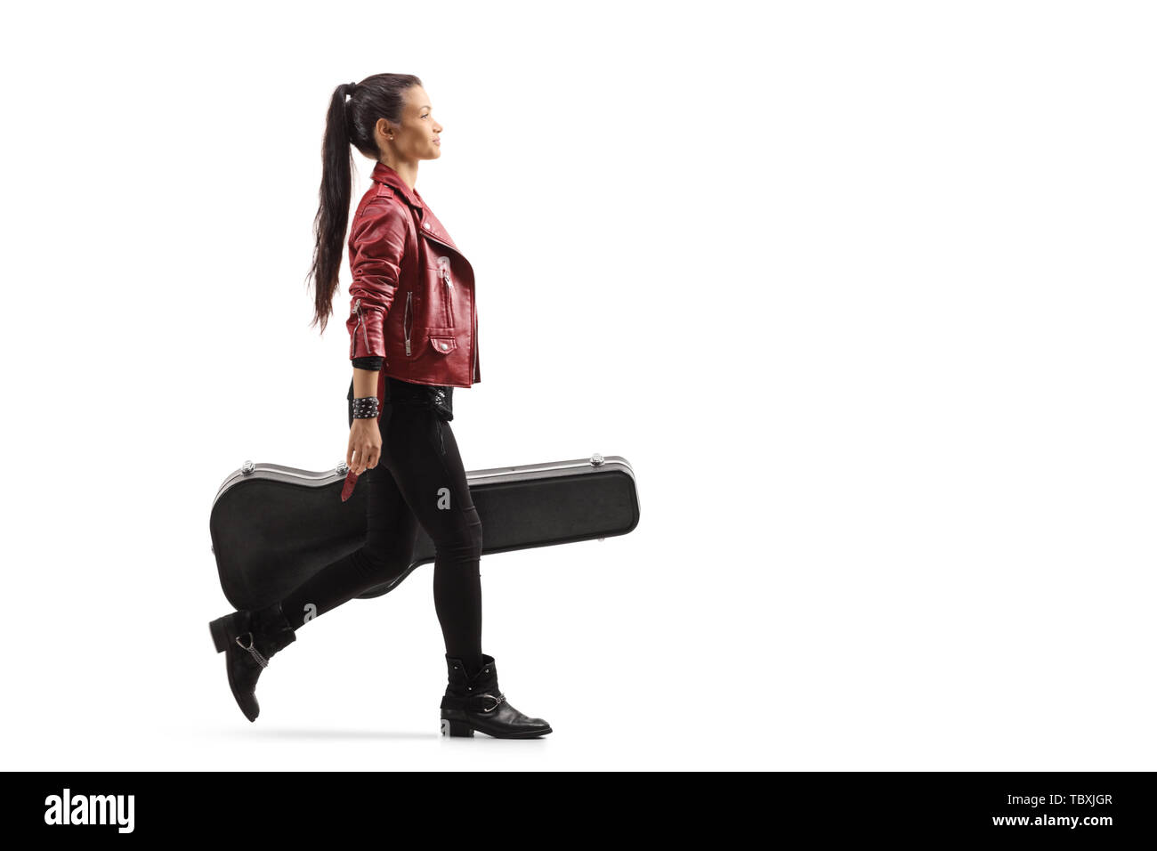 Lunghezza piena ripresa di profilo di un musicista femmina camminare e portare una chitarra in un caso isolato su sfondo bianco Foto Stock