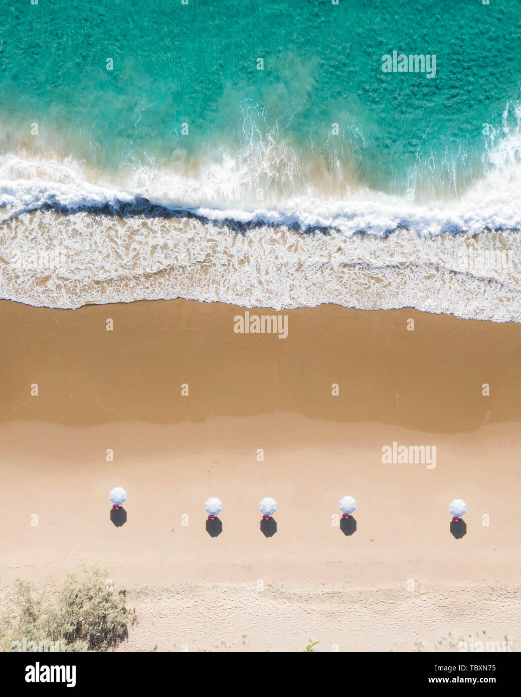 Spiaggia Vista aerea di ombrelli, onde, blu oceano e rilassante vibes nella costa orientale dell'Australia Foto Stock