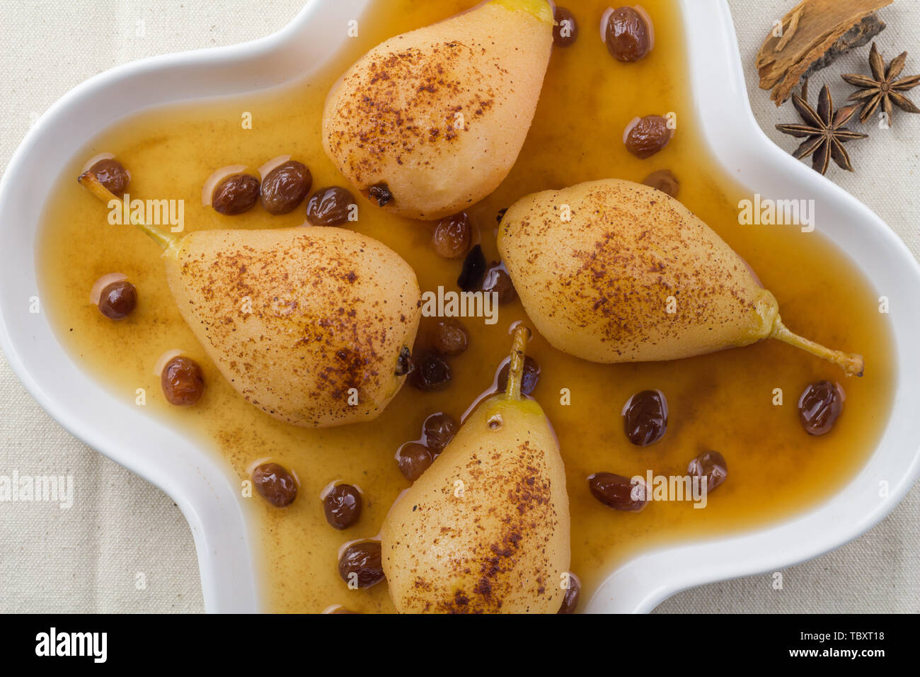 Pere affogato in raisin salsa alla vaniglia in piastra bianca - Spiced Pear backgroun - top view image Foto Stock
