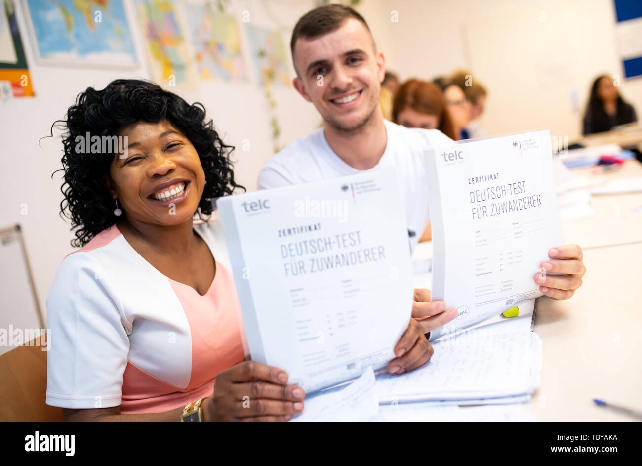 Monaco di Baviera, Germania. 04 Giugno, 2019. Angela Nwaubani dalla Nigeria e Enver Latifi dal Kosovo sono felice circa i loro certificati 'Deutsch-Test für Zuwanderer" (test di tedesco per gli immigrati che hanno ricevuto per il successo della loro partecipazione a un corso di integrazione per gli immigrati dell'Ufficio federale della migrazione (BAMF). Credito: Sven Hoppe/dpa/Alamy Live News Foto Stock