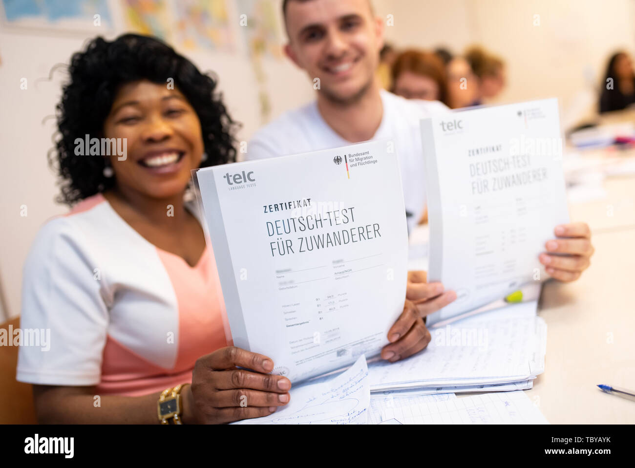 Monaco di Baviera, Germania. 04 Giugno, 2019. Angela Nwaubani dalla Nigeria e Enver Latifi dal Kosovo sono felice circa i loro certificati 'Deutsch-Test für Zuwanderer" (test di tedesco per gli immigrati che hanno ricevuto per il successo della loro partecipazione a un corso di integrazione per gli immigrati dell'Ufficio federale della migrazione (BAMF). Credito: Sven Hoppe/dpa - Attenzione: nomi scritti nell'immagine pixeled per motivi legali/dpa/Alamy Live News Foto Stock