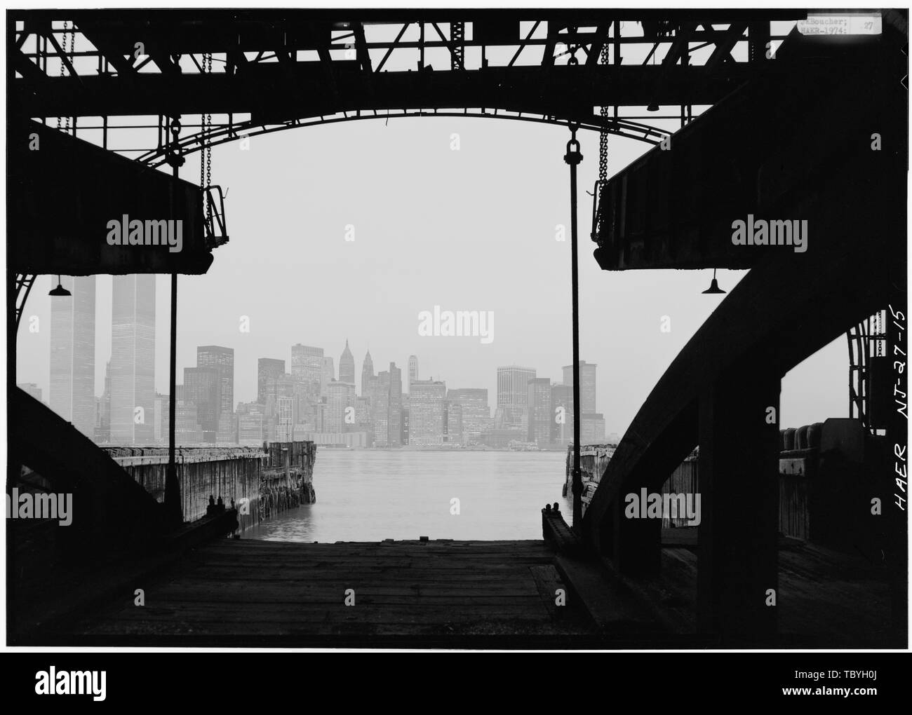 Manhattan dalla porta di traghetti passerelle sospese in alto a sinistra e in alto a destra. Ferrovia Centrale del New Jersey, Jersey City Terminal Traghetti, Johnson Avenue al Fiume Hudson, Jersey City, Hudson County, NJ Inglese: Vista di Lower Manhattan con le Torri Gemelle, dall'ex città di Jersey Ferry Terminal della ferrovia centrale di New Jersey, situato sul fiume Hudson in Jersey City, New Jersey. Fotografia (c.1970s): HAER-storico di ingegneria americana registrare le immagini del New Jersey. HAER significato il traghetto scivola, capannoni e sale comprendono l'Harbourside elemento della Ferrovia Centrale del nuovo ger Foto Stock