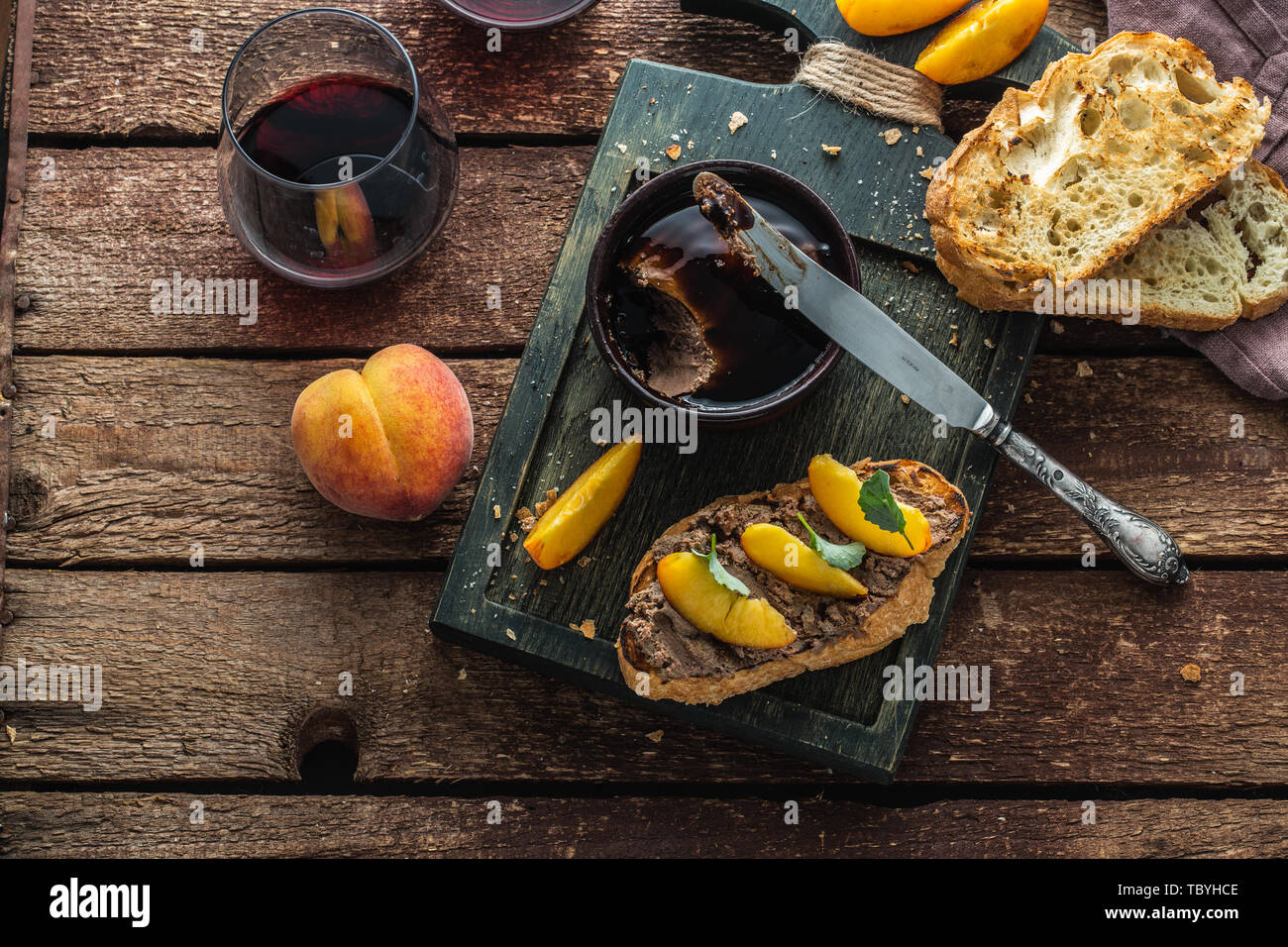 Paté di fegato con griiled pane e pesche, di stile rustico. Foto Stock