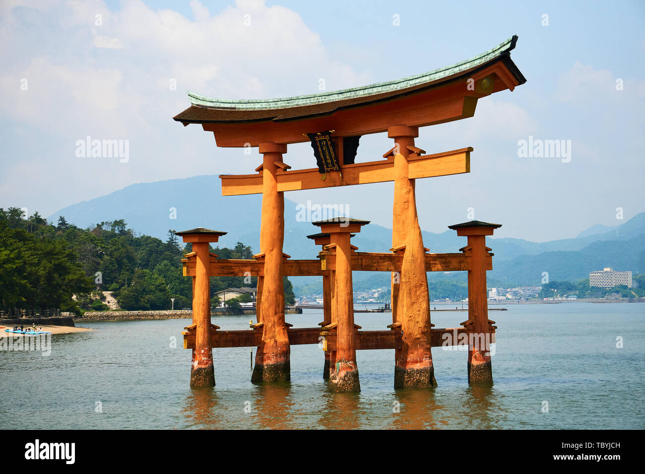 Il vermiglio torii (santuario gate) in acqua ad alta marea (floating gate), Itsukushima Jinja santuario di Miyajima, Giappone, in un assolato pomeriggio di estate. Foto Stock