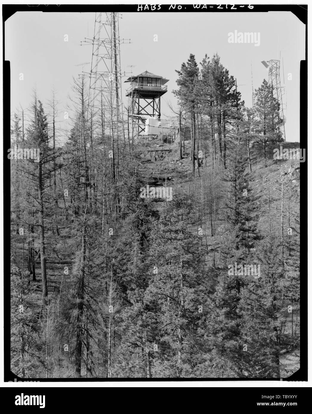 Nord aide vista obliqua di lookout tower è stata presa con un teleobiettivo 72mm lente dal crinale in esecuzione n e e dal vertice. La telecamera è sottolineato il filo di acciaio inossidabile, questa fotografia è la migliore vista della torre di tetto. In tutte le altre fotografie più stretta, l'angolo di vista, come dettato dal terreno, preclude buone vedute del tetto. Chelan Butte Lookout, vertice di Chelan Butte, Chelan, Chelan County, WA Foto Stock