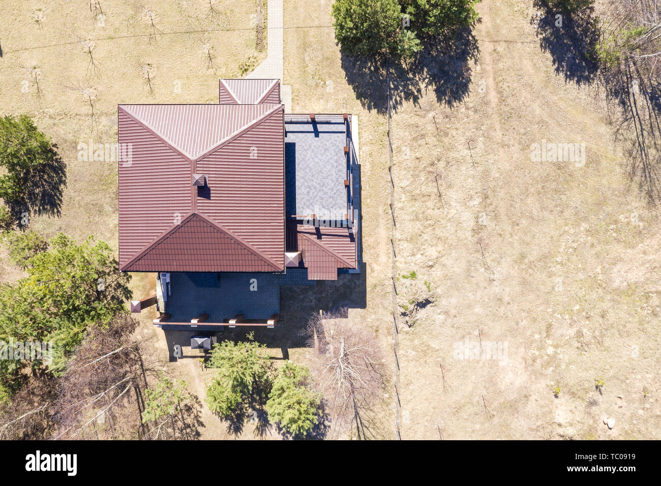 Casa rurale con un tetto rosso in campagna a molla, antenna vista superiore Foto Stock