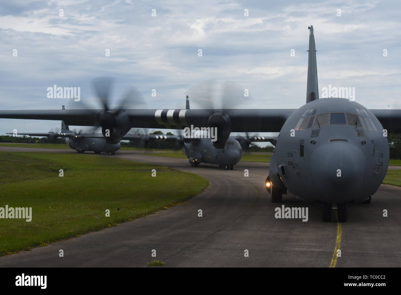 Tre C-130J Super Hercules, assegnato per la trentasettesima Airlift Squadron su Ramstein Air Base, Germania, taxi per la pista prima di decollare e che partecipano a una formazione pratica volo vicino a Cherbourg, Francia, giugno 2, 2019. Durante la seconda metà della formazione volo il filo C-130J, volato da Lt. Col. Alex Miller, 37th come capo pilota e il cap. Joe Rippe, 37th come co-pilota, abbassato la rampa per visualizzare una bandiera americana dove è sventolato nel vento sulle spiagge della Normandia. (U.S. Air Force foto di Senior Airman Kristof J. Rixmann) Foto Stock
