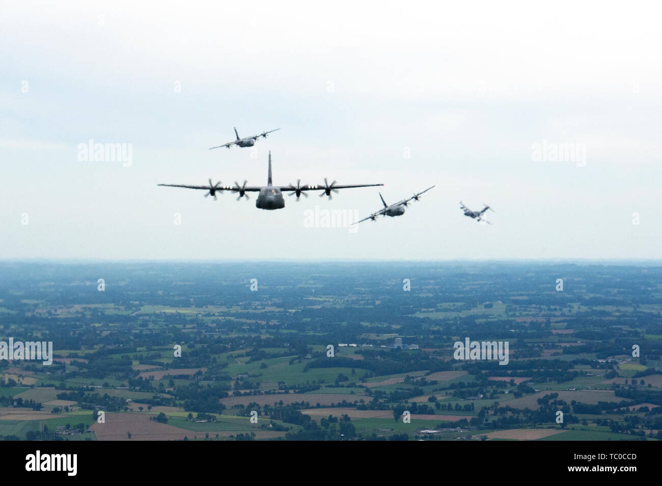 Tre C-130J Super Hercules, assegnato per la trentasettesima Airlift Squadron su Ramstein Air Base, Germania, volare come un C-17 Globemaster, assegnati alla riserva 446th ala sulla Royal Air Force Mildenhall, Inghilterra, sentieri un miglio dietro la formazione durante un volo di pratica vicino a Cherbourg, Francia, giugno 2, 2019. Il percorso intrapreso durante questa formazione pratica di volo è stato il percorso compiuto dalle loro rispettive unità' aeromobile legacy su DDay, Giugno 6, 1944. (U.S. Air Force foto di Senior Airman Kristof J. Rixmann) Foto Stock
