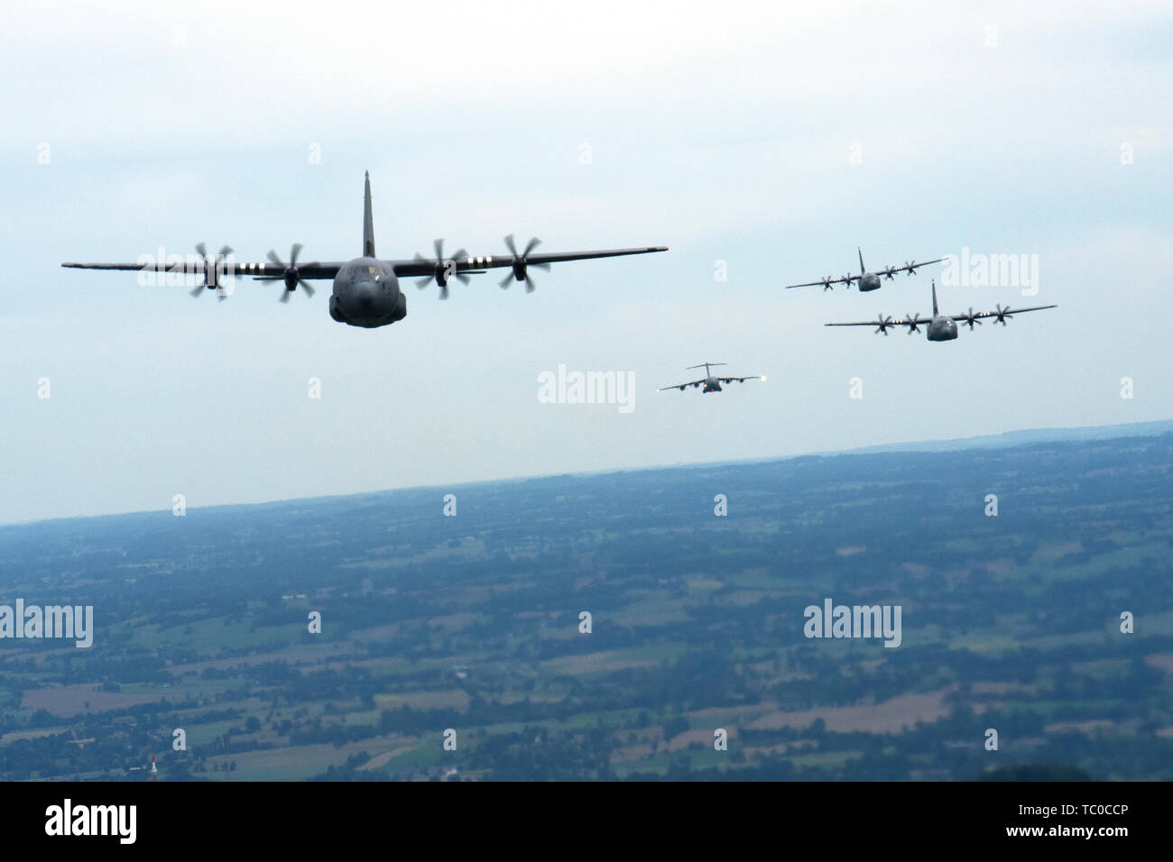 Tre C-130J Super Hercules, assegnato per la trentasettesima Airlift Squadron su Ramstein Air Base, Germania, volare come un C-17 Globemaster, assegnati alla riserva 446th ala sulla Royal Air Force Mildenhall, Inghilterra, sentieri un miglio dietro la formazione durante un volo di pratica vicino a Cherbourg, Francia, giugno 2, 2019. 6 giugno segneranno il settantacinquesimo anniversario del DDay dove oltre 1.000 SERVIZIO DEGLI STATI UNITI I membri parteciperanno alla commemorazione. (U.S. Air Force foto di Senior Airman Kristof J. Rixmann) Foto Stock