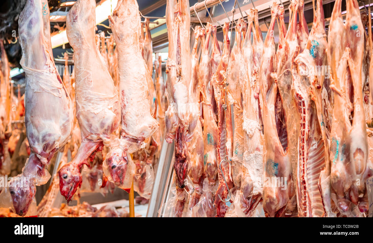 Mercato di carne concetto. Agnello, pecora impiccato su ganci al di fuori del negozio di macellaio pronto per essere venduto. Non cotti carni di montone per lo sfondo, closeup. Foto Stock