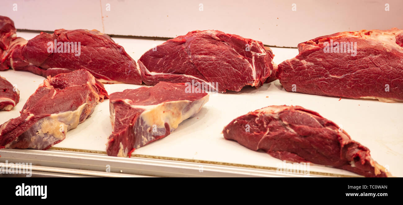 Concetto di carne. Carne di manzo crudo in grossi pezzi a Butcher Shop pronto per essere venduto. Carne di vitello cruda closeup, banner. Foto Stock