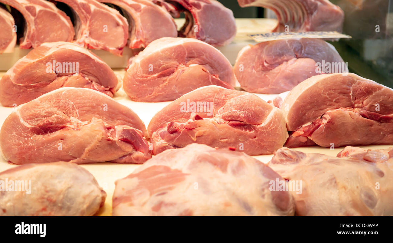 Concetto di carne. Carne di maiale cruda in grossi pezzi al di fuori del negozio di macellaio pronto per essere venduto. Maiale cruda per lo sfondo, closeup. Foto Stock