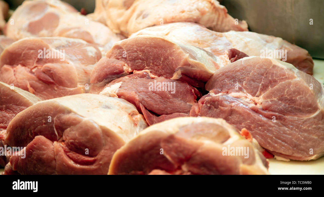 Concetto di carne. Carne di maiale cruda in grossi pezzi a Butcher Shop pronto per essere venduto. Maiale cruda per lo sfondo, closeup. Foto Stock