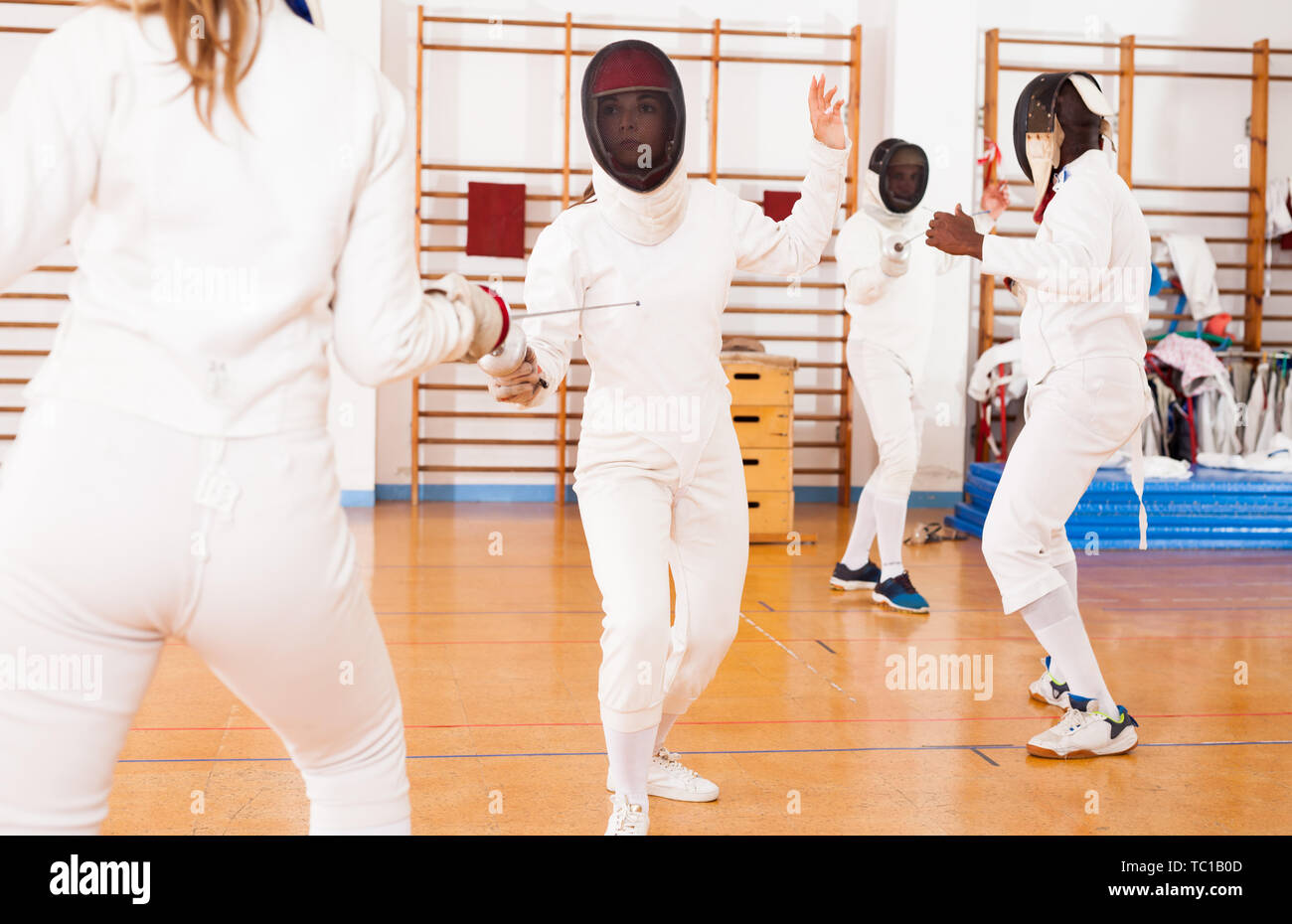 Gruppo di schermitori in allenamento di scherma, tecniche di esercizio nella battaglia Foto Stock