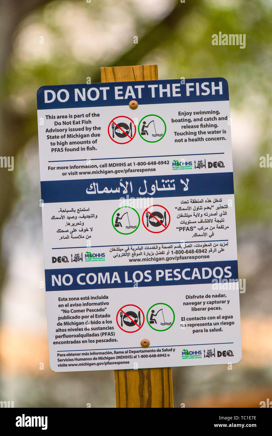 PFAS segno multilingue di contaminazione chimica - 'non mangiare il pesce' a Kent Lake, alimentato dall'inquinamento del fiume Huron in Michigan, USA. Foto Stock