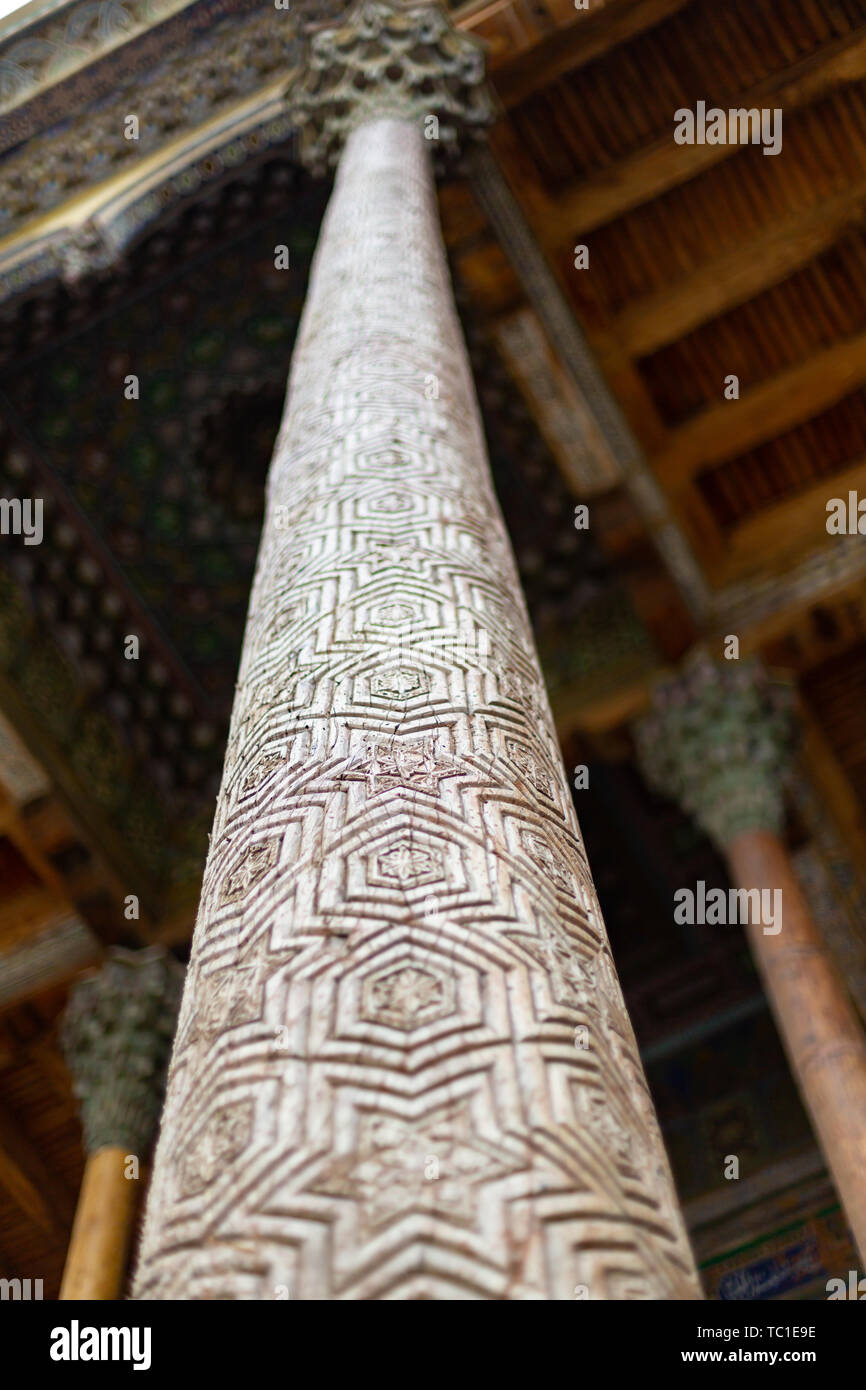 Olmo tradizionale scultura in legno colonne ornate con kokands e soffitto. Le colonne di legno sostenere il tetto del iwan. Uzbekistan tradi nazionale Foto Stock