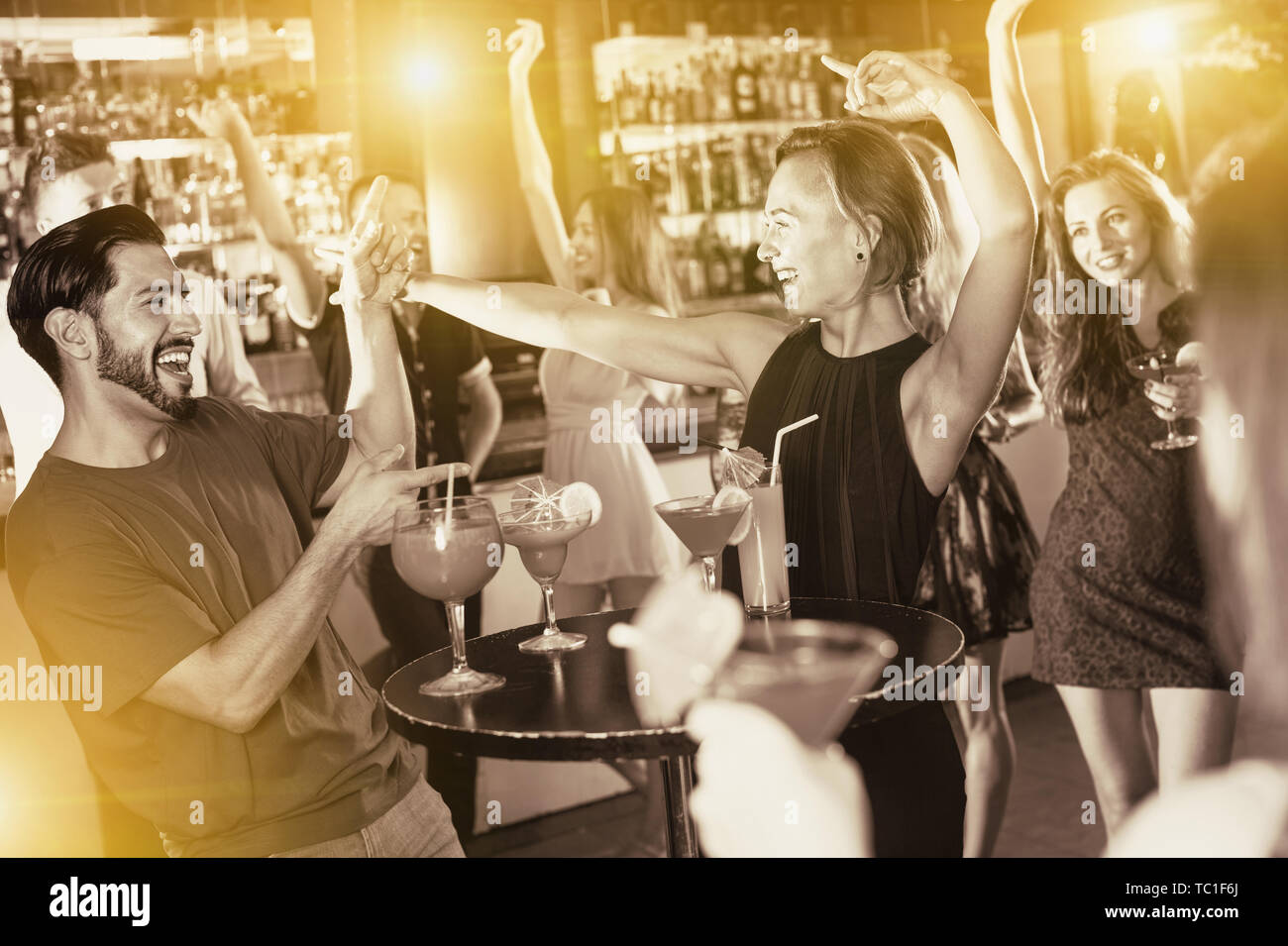 Felice positivo uomo sorridente con giovani donne stanno godendo il partito in bar. Foto Stock