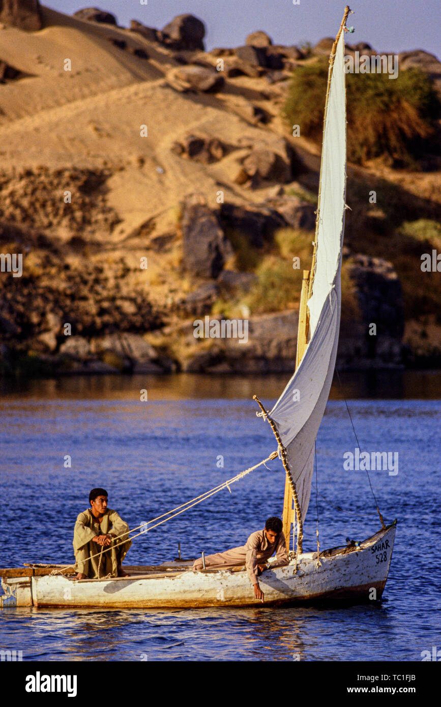 Luxor, Egitto. Due ragazzi navigano le loro piccole felucca barche a vela sul fiume Nilo. Foto: © Simon Grosset. Archivio: immagine digitalizzata dalla un originale transpa Foto Stock