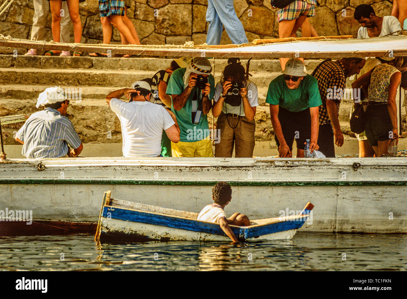 Egitto: turistica prendendo le foto di un ragazzo in una piccola barca sul fiume Nilo. Foto: © Simon Grosset. Archivio: immagine digitalizzata dalla un originale transparenc Foto Stock