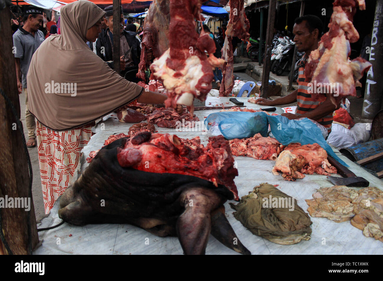 Una donna musulmana acquista la carne ad un tradizionale mercato durante il 'Meugang' nella tradizione Lhokseumawe. La tradizione di 'Meugang' nel senso di acquistare la carne dal mercato per la cottura è stata andando su per centinaia di anni da sotto la leadership di Sultan Iskandar Muda nell'anno 1607 al 1636. Questa tradizione è stata effettuata durante l'inserimento di Ramadan, Eid Fitri e l'Eid al-Adha ogni anno. Foto Stock