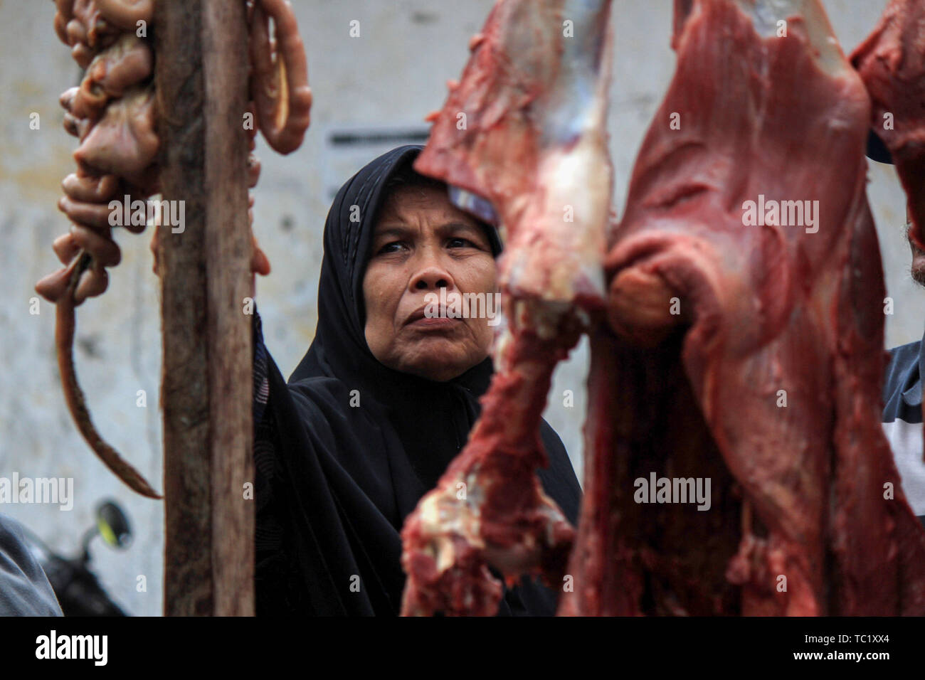 Una donna musulmana acquista la carne ad un tradizionale mercato durante il 'Meugang' nella tradizione Lhokseumawe. La tradizione di 'Meugang' nel senso di acquistare la carne dal mercato per la cottura è stata andando su per centinaia di anni da sotto la leadership di Sultan Iskandar Muda nell'anno 1607 al 1636. Questa tradizione è stata effettuata durante l'inserimento di Ramadan, Eid Fitri e l'Eid al-Adha ogni anno. Foto Stock