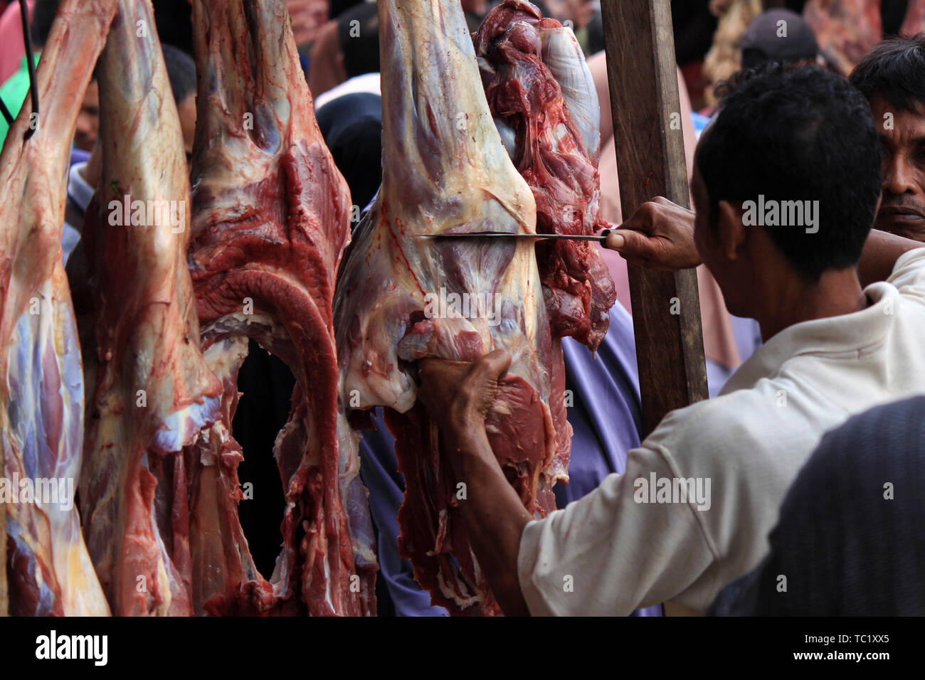 Un commerciante vende carne ad un mercato tradizionale per i musulmani durante il 'Meugang' nella tradizione Lhokseumawe. La tradizione di 'Meugang' nel senso di acquistare la carne dal mercato per la cottura è stata andando su per centinaia di anni da sotto la leadership di Sultan Iskandar Muda nell'anno 1607 al 1636. Questa tradizione è stata effettuata durante l'inserimento di Ramadan, Eid Fitri e l'Eid al-Adha ogni anno. Foto Stock