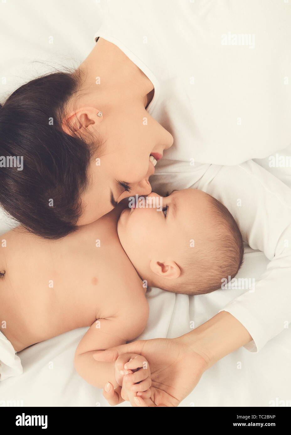 Mamma e Bambino giacente in letto naso a naso Foto Stock