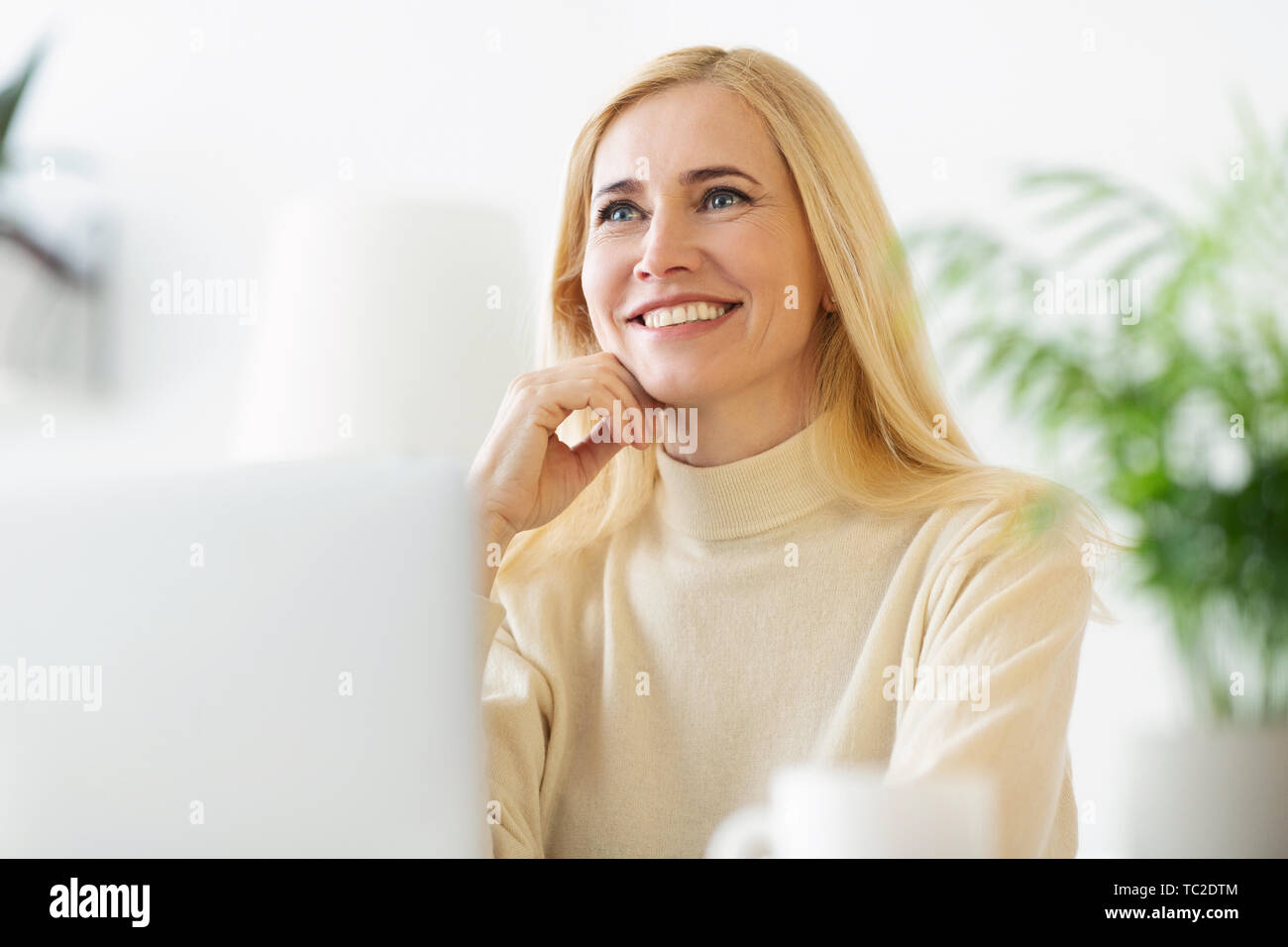 Donna felice pensare al futuro di vacanza a casa Foto Stock